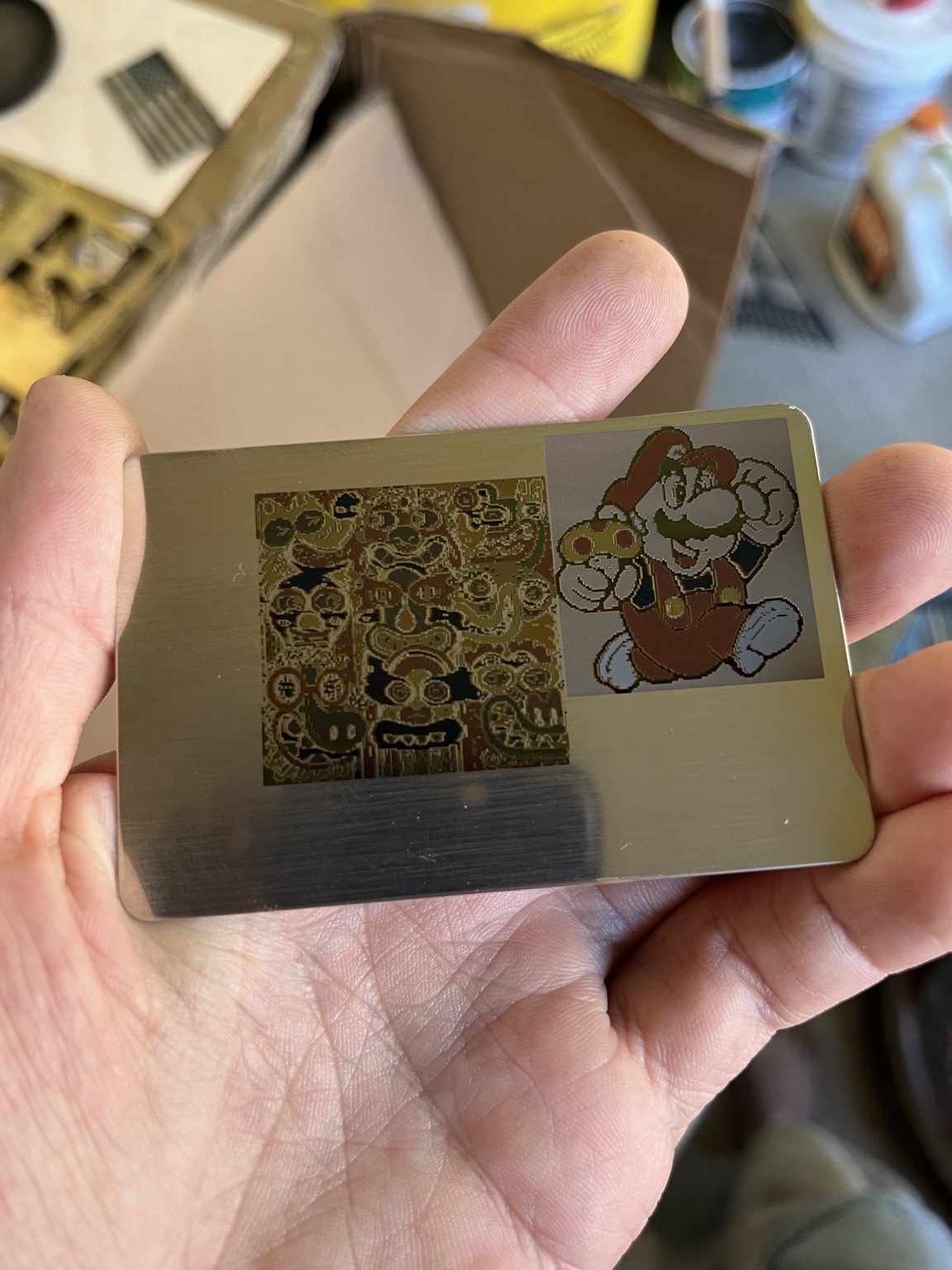 A custom laser-engraved stainless steel card held in one hand
